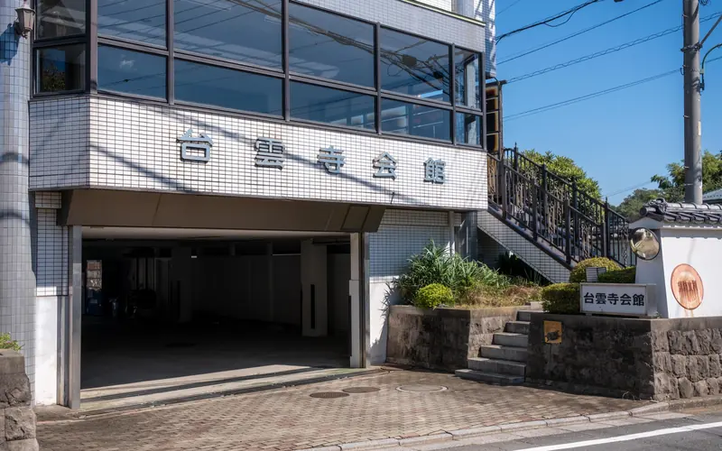 台雲寺会館の館名サインと階段脇の看板