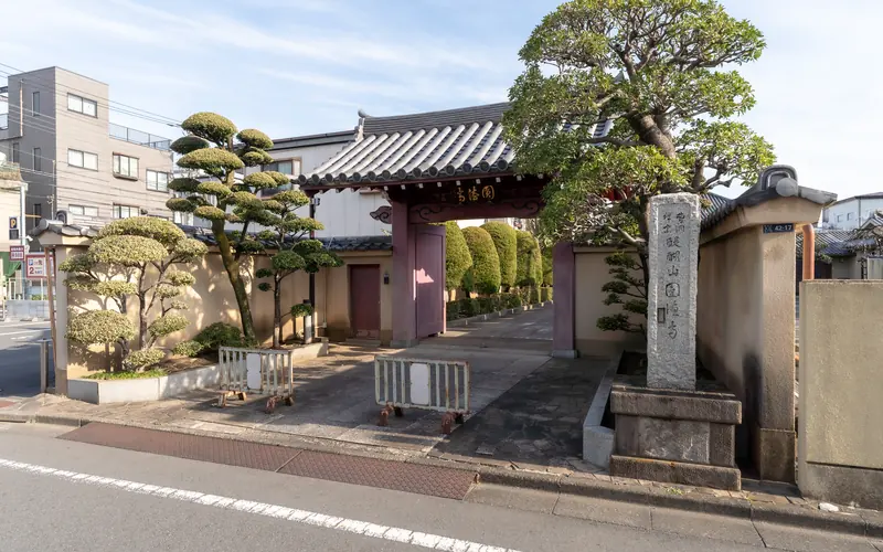 円徳寺赤門会館の山門と寺号標(斜め)