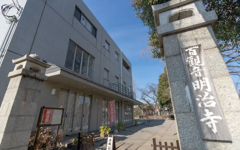明治寺 百観音沙羅会館の寺号標と会館の外観