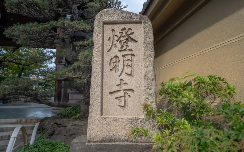 燈明寺(明聖会館)の寺号標(石段脇)