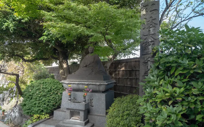 燈明寺(明聖会館)の境内の石像と石柱