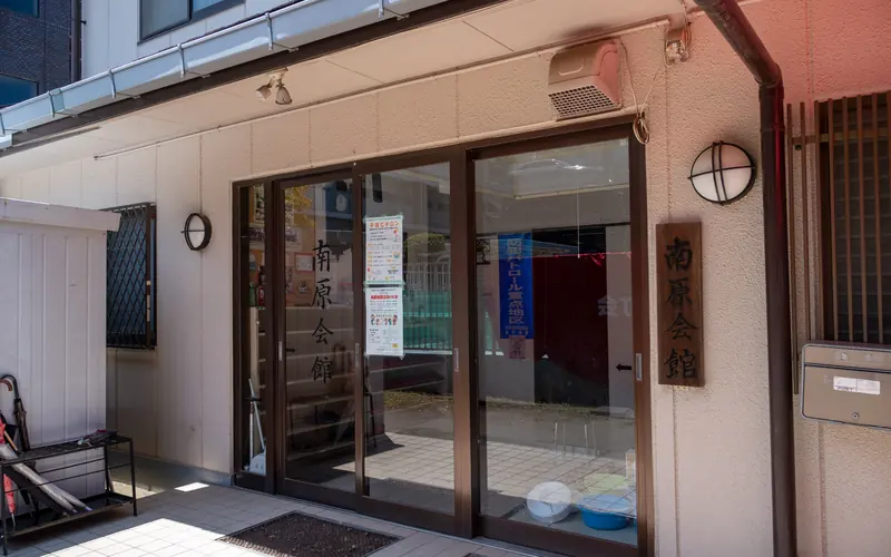 南原会館の入口の引き戸と看板（斜め）