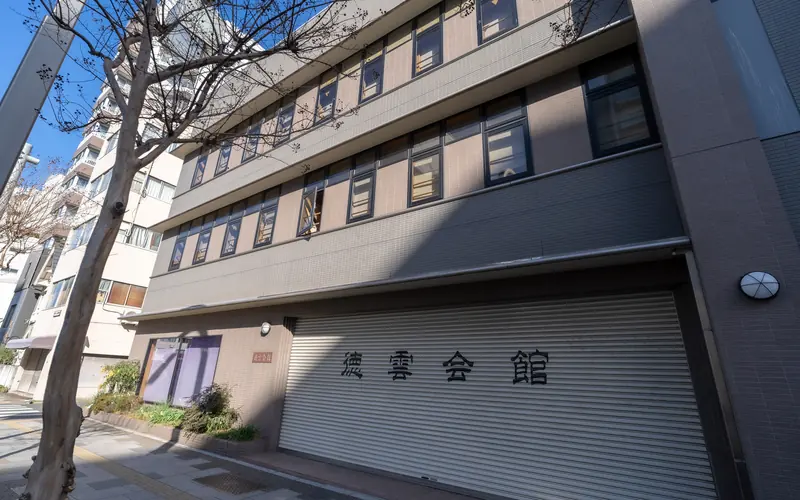 徳雲会館の建物の外観（樹木越し）