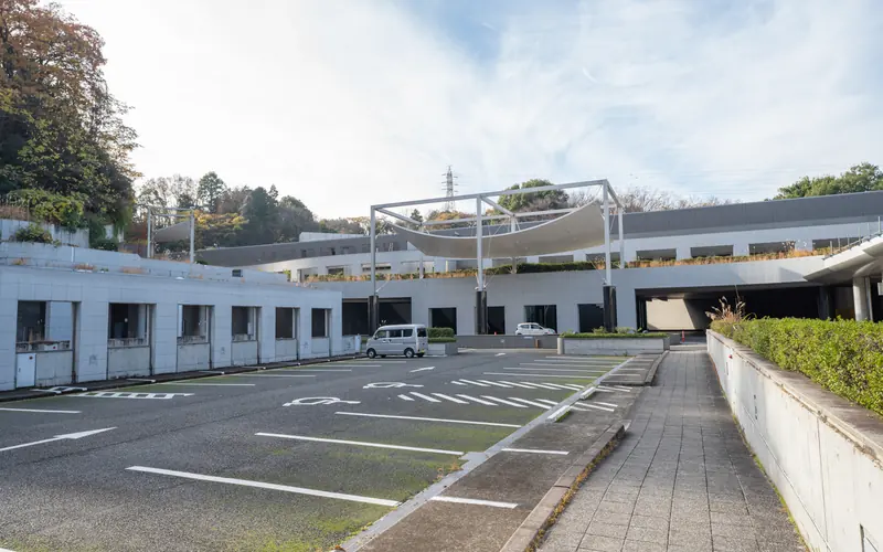 横浜市北部斎場の屋外駐車場と建物(歩道側)